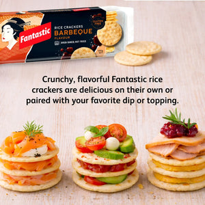 Barbeque rice crackers with gourmet toppings, tomatoes, salmon, and cheese on a wooden surface.