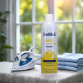 Faultless lemon scent ironing spray starch can next to an iron and folded blue shirts on ironing board