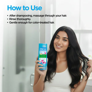Smiling woman with long black hair holding Finesse Volumizing Conditioner in bright bathroom with usage instructions
