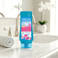 Finesse moisturizing conditioner bottle on bathroom counter near towel and sink faucet