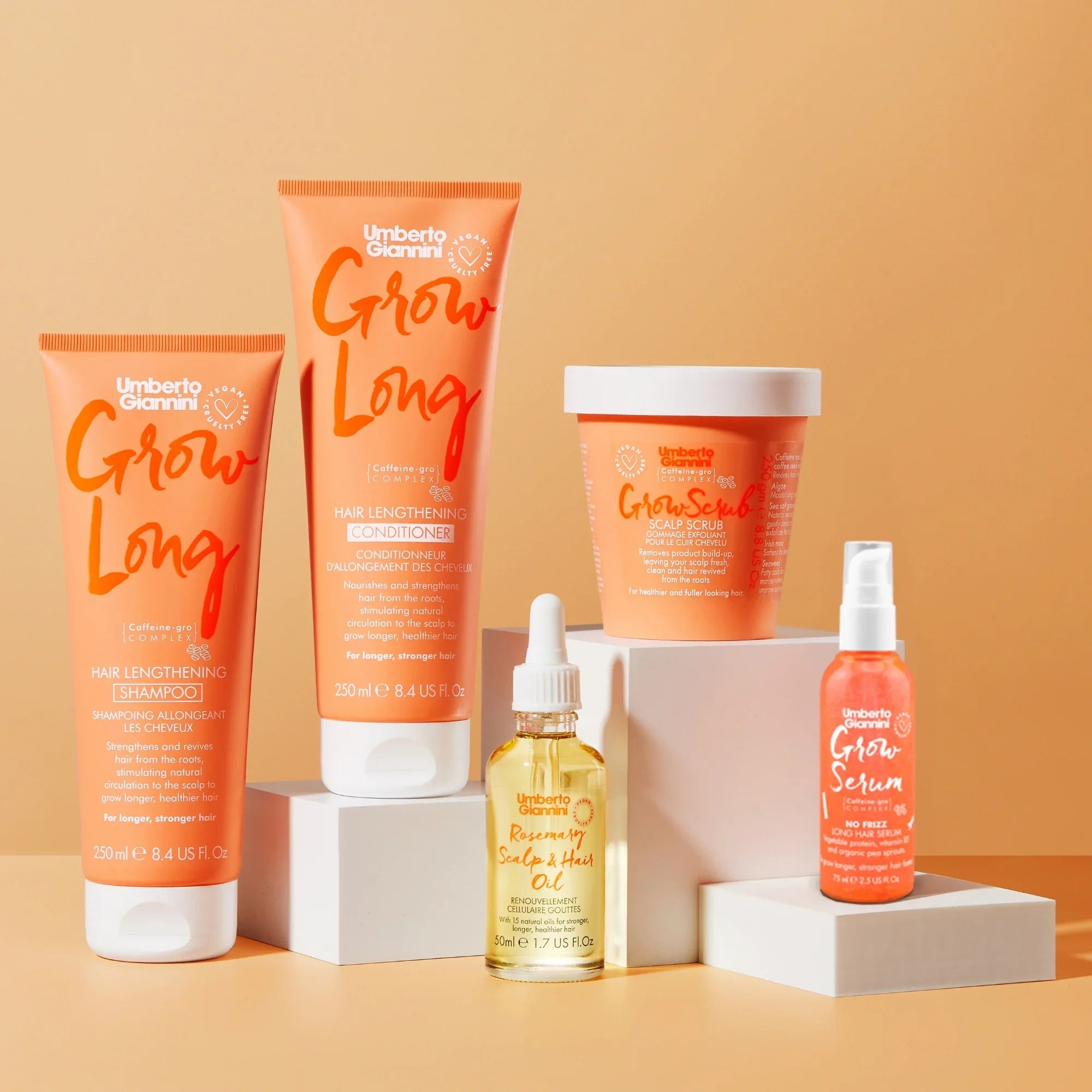 Umberto Giannini Grow Long hair lengthening shampoo, conditioner, scalp scrub, rosemary scalp oil, and grow serum set on beige blocks