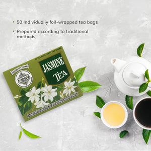 Jasmine tea box with Ceylon tea bags, teapot, green tea leaves, and tea cups on light surface