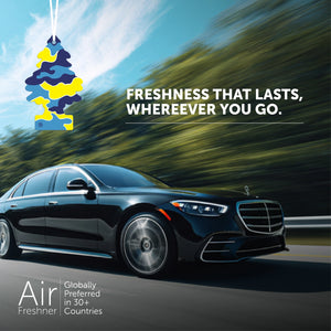 Black luxury car driving on road with blue sky and trees, featuring hanging camo-patterned air freshener