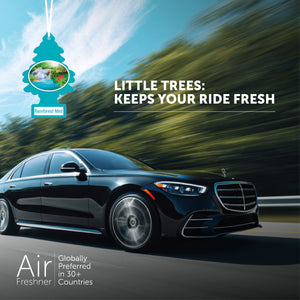 Black luxury car driving on highway with Little Trees Rainforest Mist air freshener hanging and text about freshness