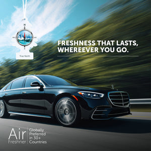 Black luxury car driving fast on highway with True North Little Trees air freshener and freshness slogan
