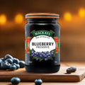 Jar of Mackays Blueberry Preserve on wooden board with fresh blueberries and warm bokeh background