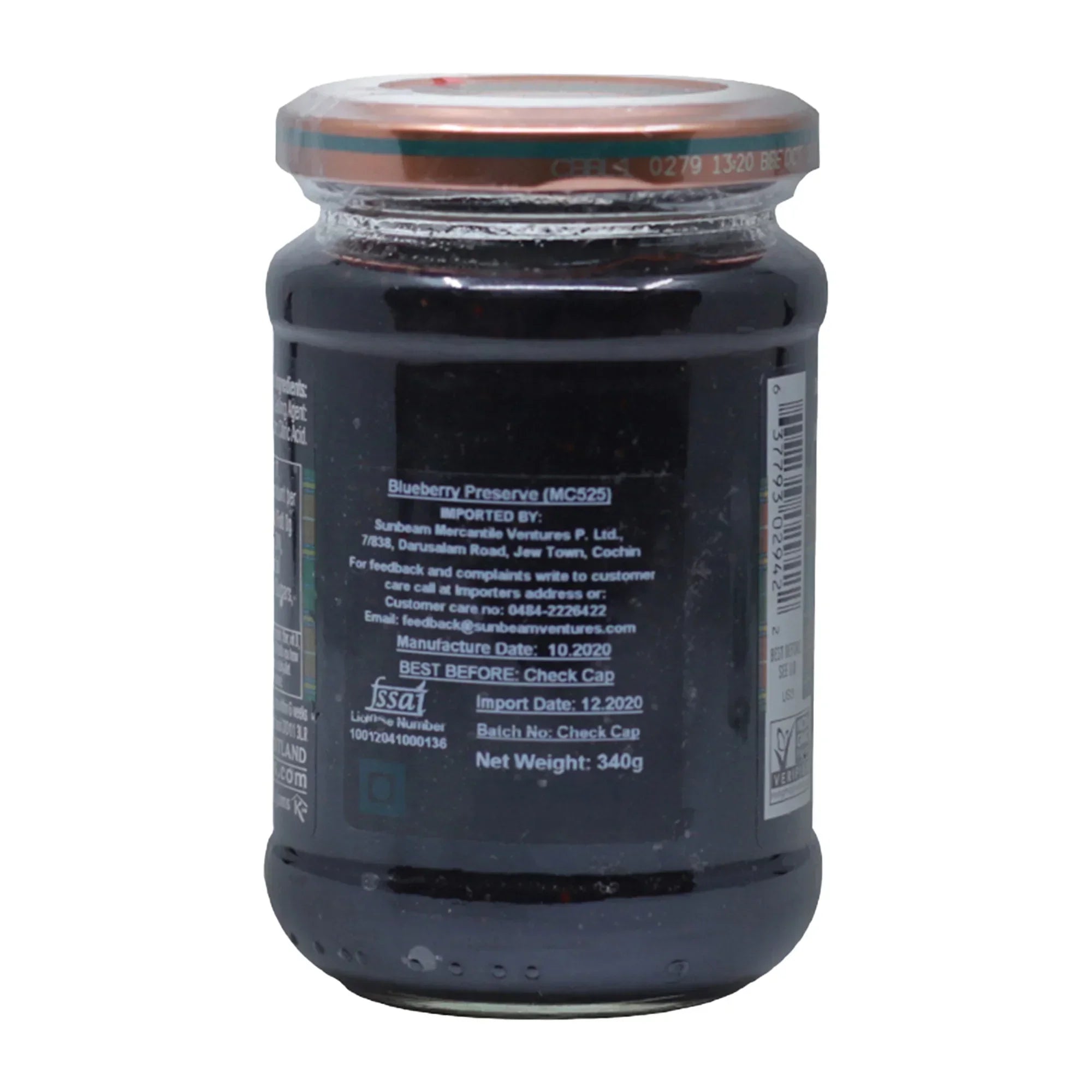 Glass jar of blueberry preserve with metal lid and label detailing import and manufacture information