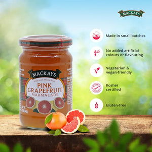 Mackays Pink Grapefruit Marmalade jar on wooden surface with fresh grapefruit halves and product benefits listed
