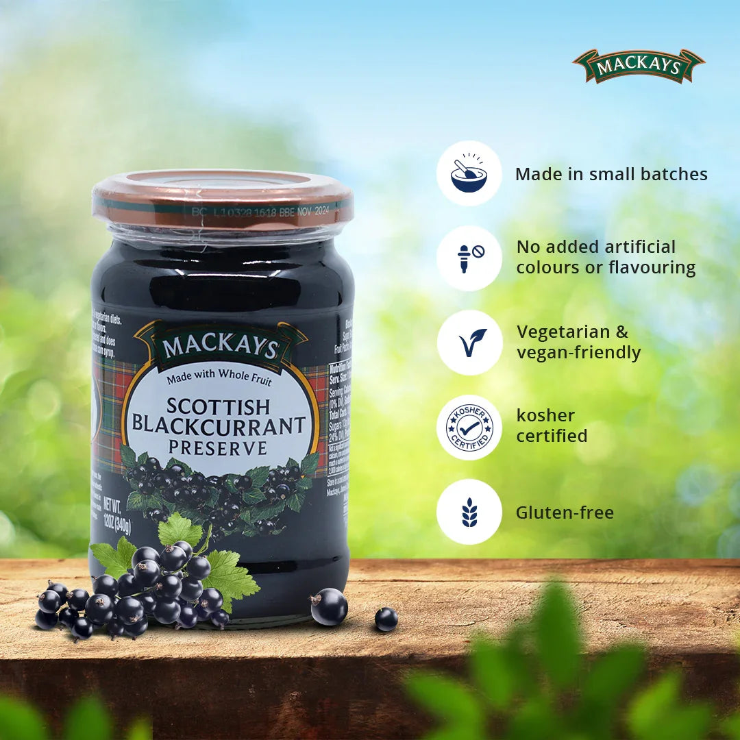 Mackays Scottish Blackcurrant Preserve jar on wooden table with fresh blackcurrants and product benefits list