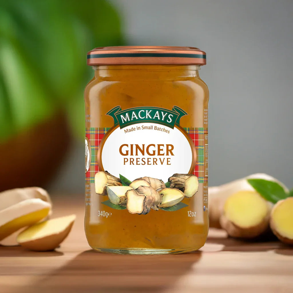 Jar of Mackays Ginger Preserve with fresh ginger roots on wooden surface