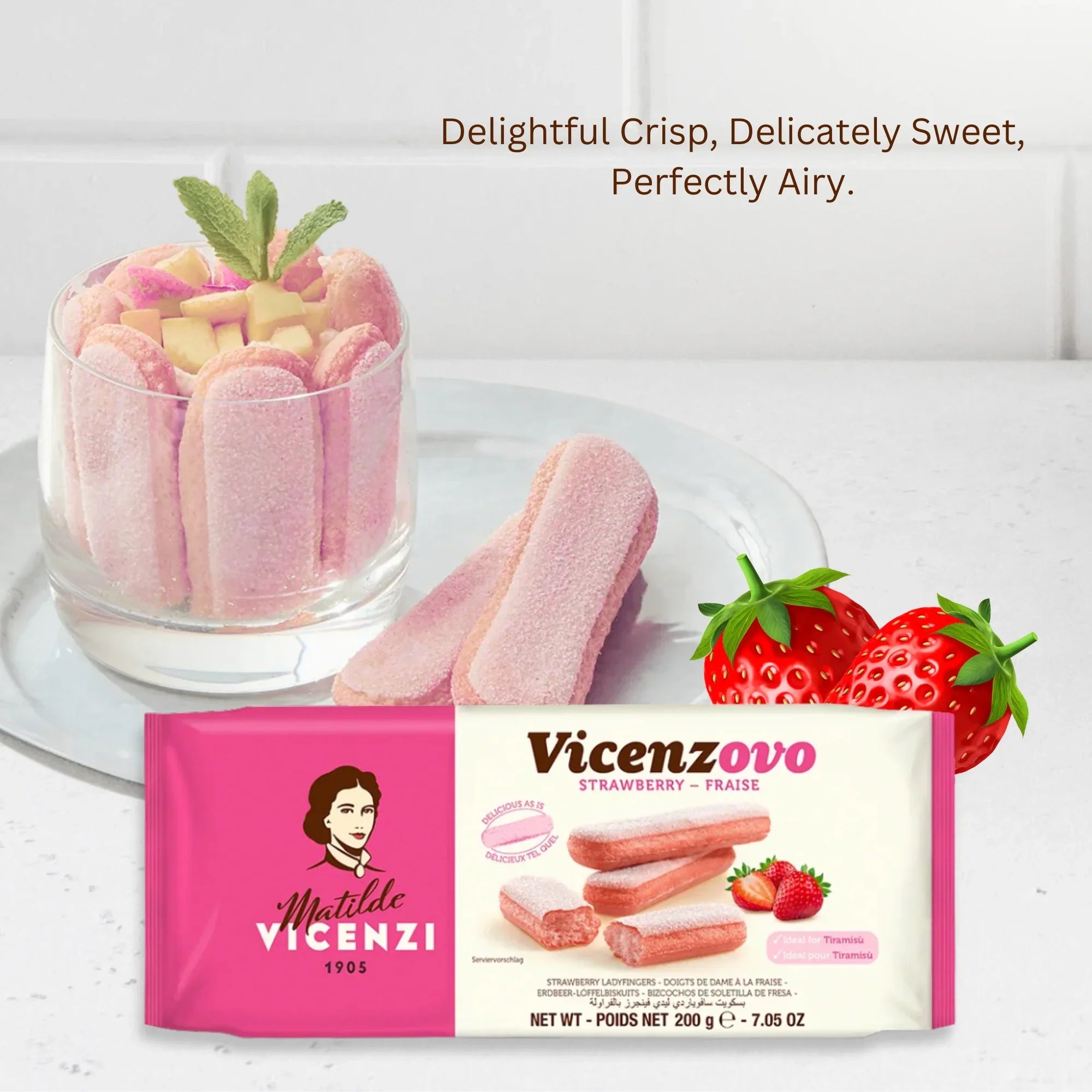 Strawberry ladyfinger biscuits in a glass dessert with package and strawberries on white plate.