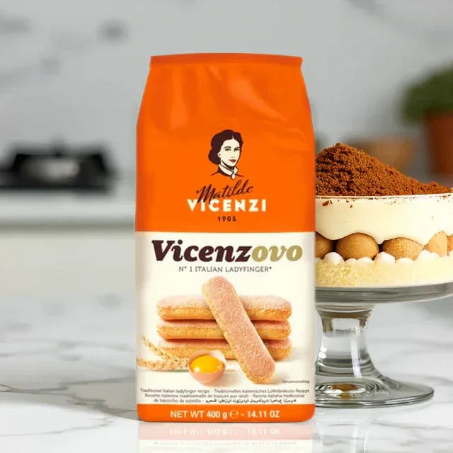 Matilde Vicenzi Italian ladyfingers Vicenzovo pack on marble counter, tiramisu dessert beside