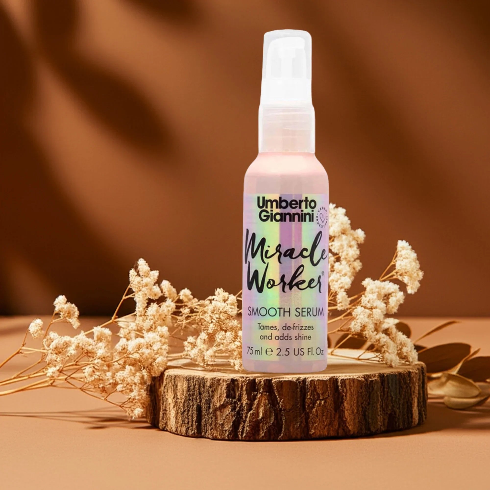 Umberto Giannini Miracle Worker Smooth Serum bottle on wooden stand with dried flowers, brown background