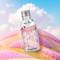 Mogu Mogu sugar free lychee flavored candy bottle with pink candy pieces in a pastel landscape