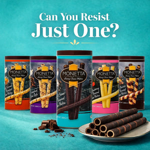 Assorted Monetta luxury cream wafer sticks in colorful tins with a plate of wafers on blue background