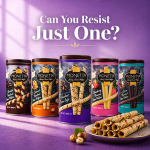 Assorted Monetta wafer stick tins with filled wafer rolls and hazelnuts on a purple background.
