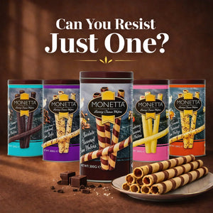 Assorted Monetta luxury cream wafer roll tins with plate of chocolate and vanilla wafer rolls