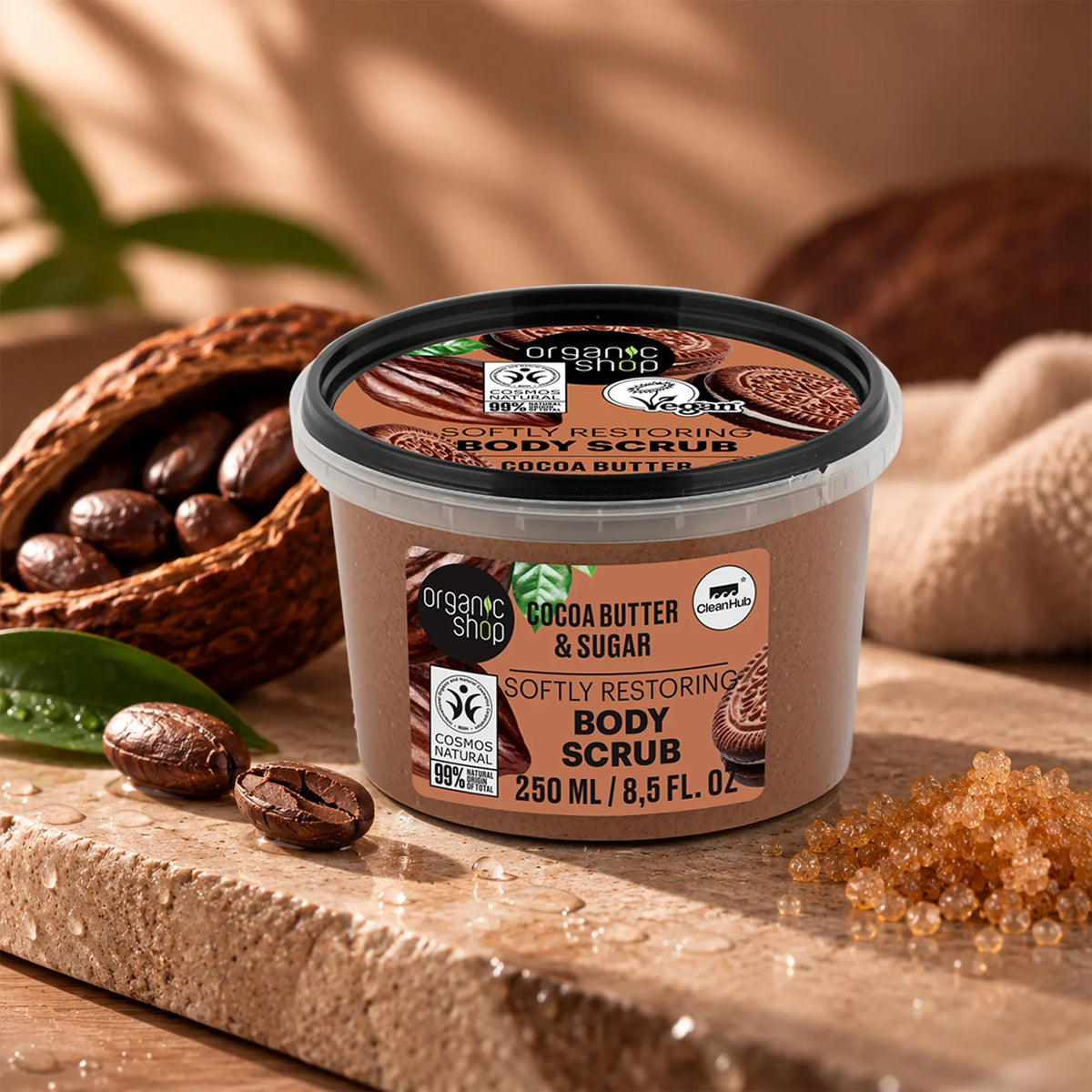 Organic Shop Cocoa Butter & Sugar Softly Restoring Body Scrub jar with cocoa beans and sugar.