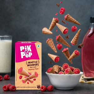 Mini waffle cones with raspberry filling, fresh raspberries, and chocolate curls in a bowl, Pik n Pop Waffle Wonders box visible.