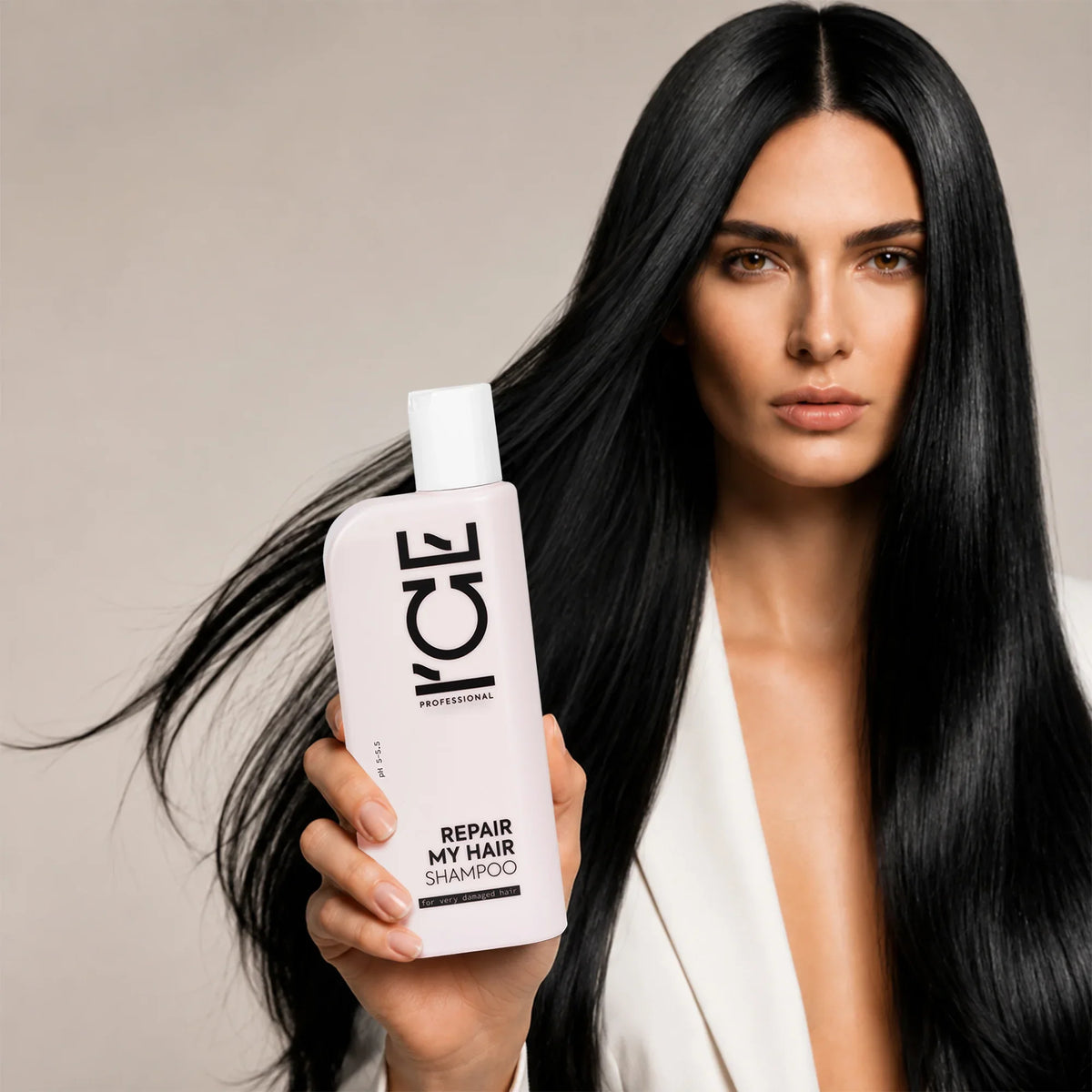 Woman with long black hair holding a bottle of ICE Professional Repair My Hair Shampoo.