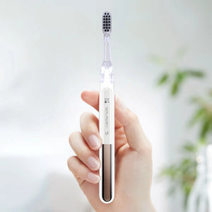 Hand holding a Soladex 5 white electric toothbrush with a black brush head.