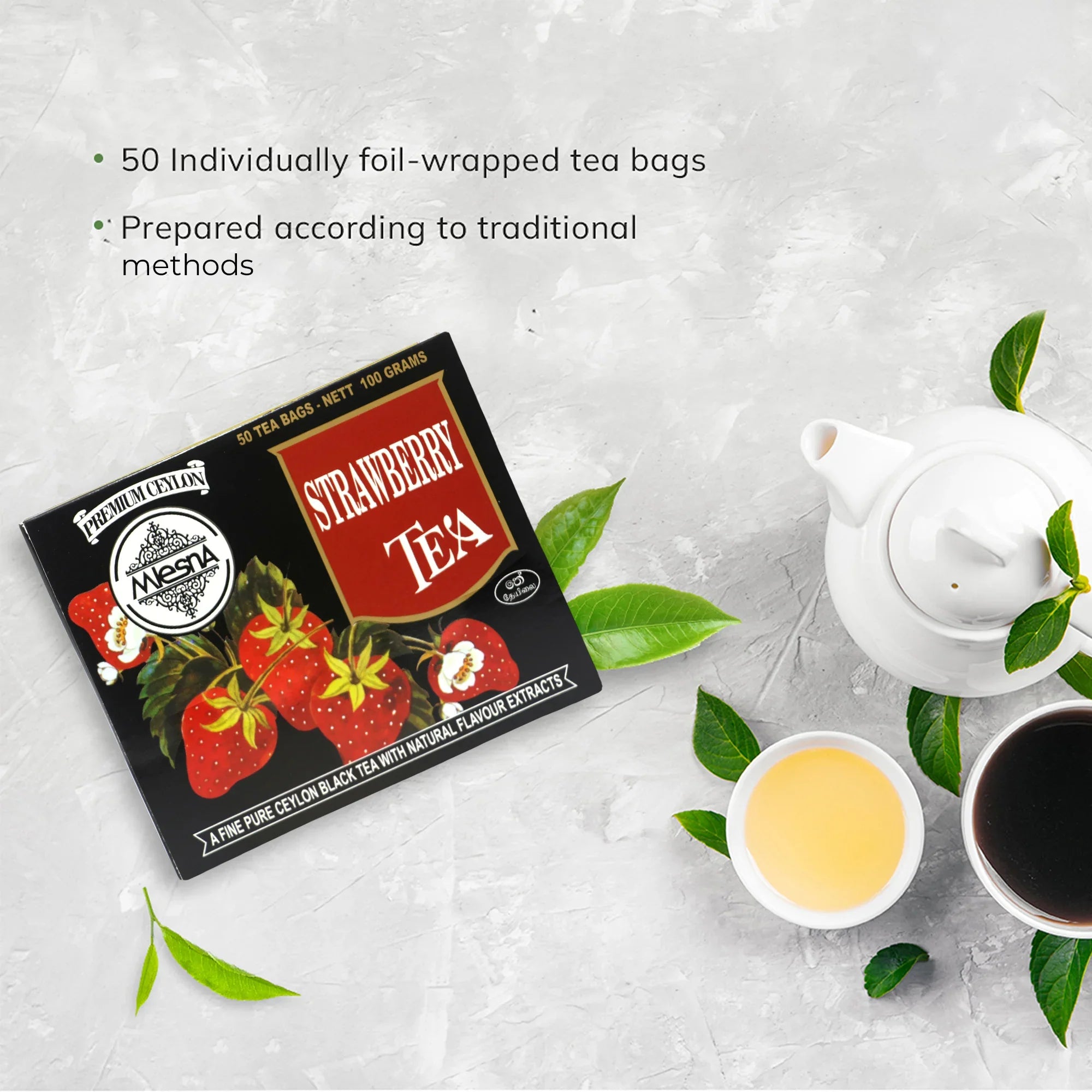 Strawberry tea box with strawberries, teapot, two tea cups, and tea leaves on a light surface