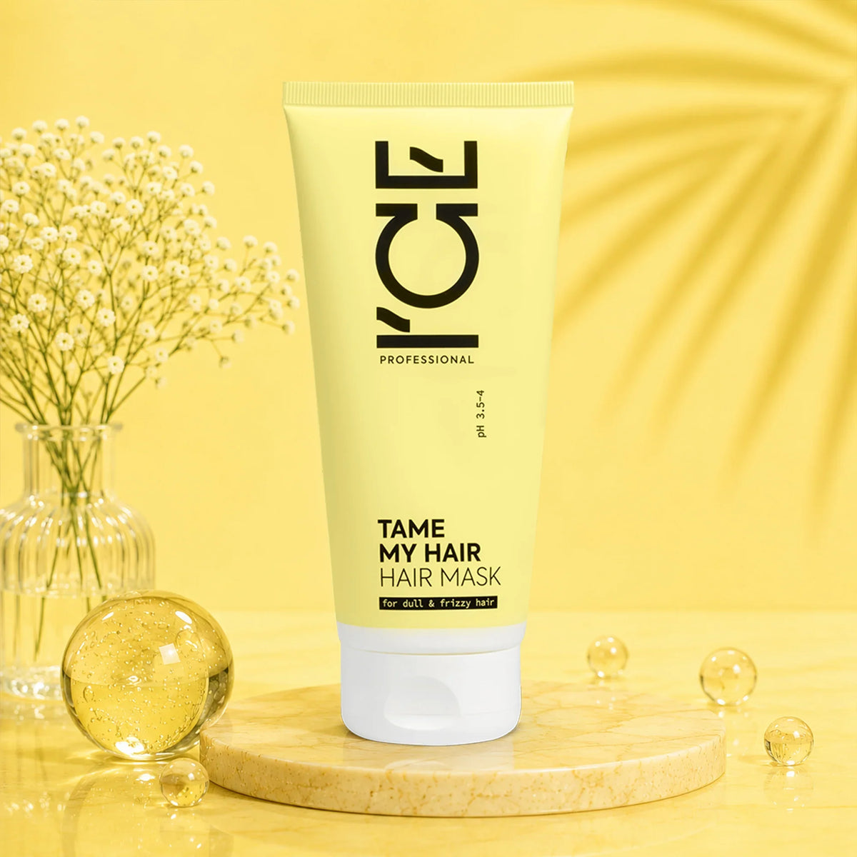 ICE Professional Tame My Hair Hair Mask tube on a marble pedestal with yellow background.