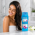 Woman in shower holding Finesse Normal 2-in-1 Shampoo + Conditioner with hyaluronic acid for shine & manageability