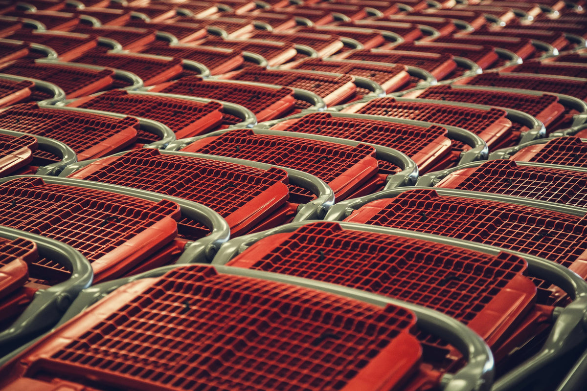 Rows of nested red shopping carts in a retail store.